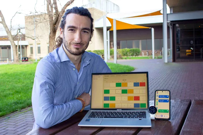 Luigi Andrea Moretti, PhD candidate at UWE Bristol, sitting outdoors with a laptop showing the MEMoPAD clinician dashboard