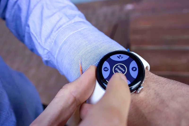 Hands wearing Google Pixel Watch 2 alongside Milbotix SmartSocks sensor for physiological monitoring